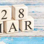 March 28th. Wooden cubes with date of 28 March on old blue wooden background.